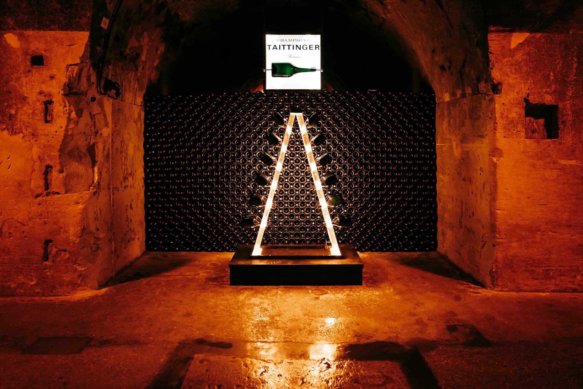 Bottles resting in a cellar rack under low light